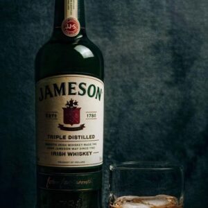 a bottle of jameson next to a glass of whiskey