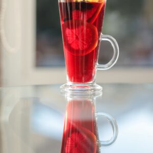A glass cup filled with liquid and a cigar