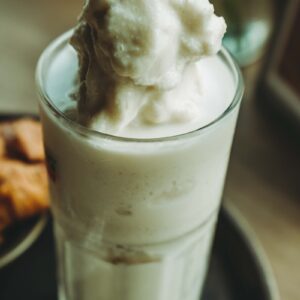 A glass of ice cream sitting on top of a plate